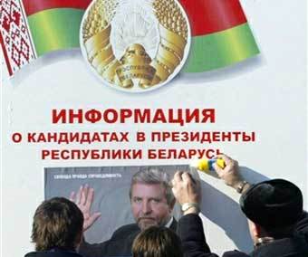 Белорусские оппозиционеры наклеивают предвыборный плакат Александра Милинкевича. Фото AFP